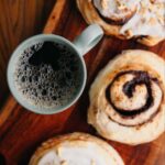 Fresh cinnamon rolls beside a mug of coffee